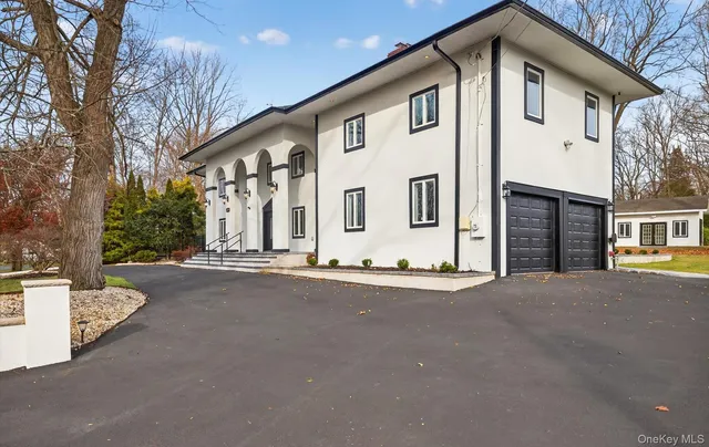 a front view of a house with a road and garage