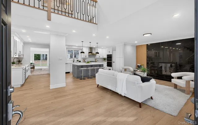 a living room with stainless steel appliances kitchen island granite countertop a refrigerator and a view of living room