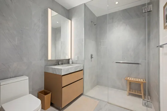 a bathroom with a granite countertop sink toilet and shower