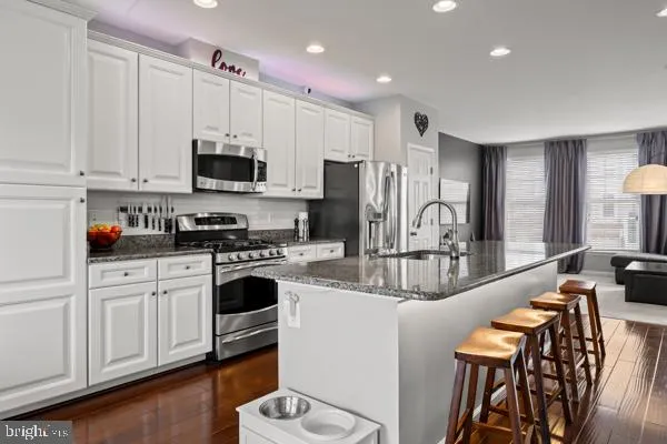 a kitchen with stainless steel appliances granite countertop a stove refrigerator sink and cabinets