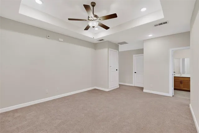 an empty room with a ceiling fan and wooden floor