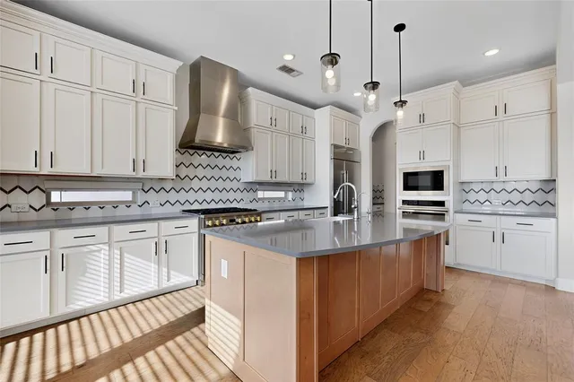 a large kitchen with granite countertop a white stove sink and cabinets