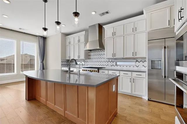 a kitchen with kitchen island granite countertop a sink cabinets and stainless steel appliances