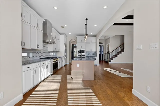 a kitchen with stainless steel appliances kitchen island a stove and a sink