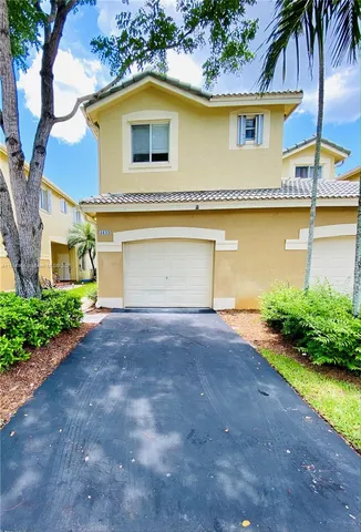 a view of a house with a yard and a garage