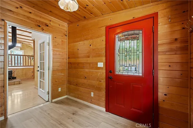 a view of a hallway with wooden floor and a bathroom