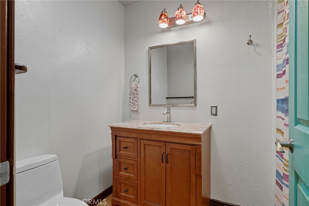 10294 Red Eye Road Oroville, CA 95965 - Photo 25 of 62 a bathroom with a toilet a sink and a mirror