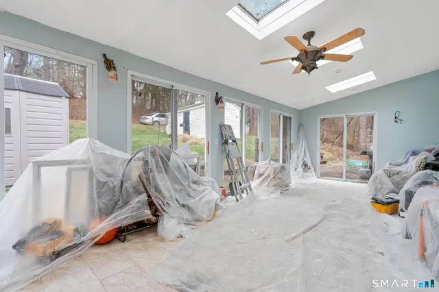 a living room with furniture a flat screen tv and a window