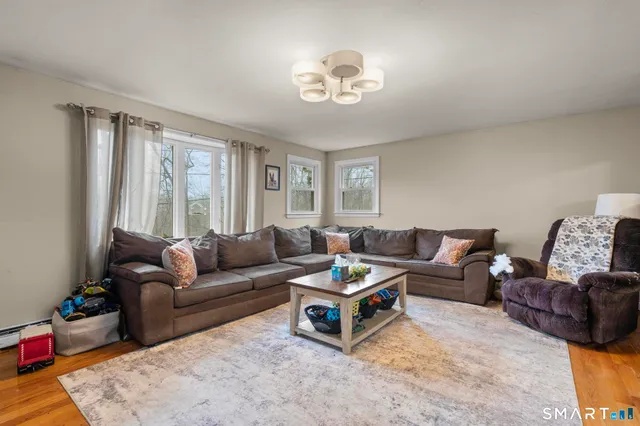 a living room with furniture and a wooden floor