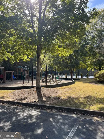 a view of a house with garden and trees in the background