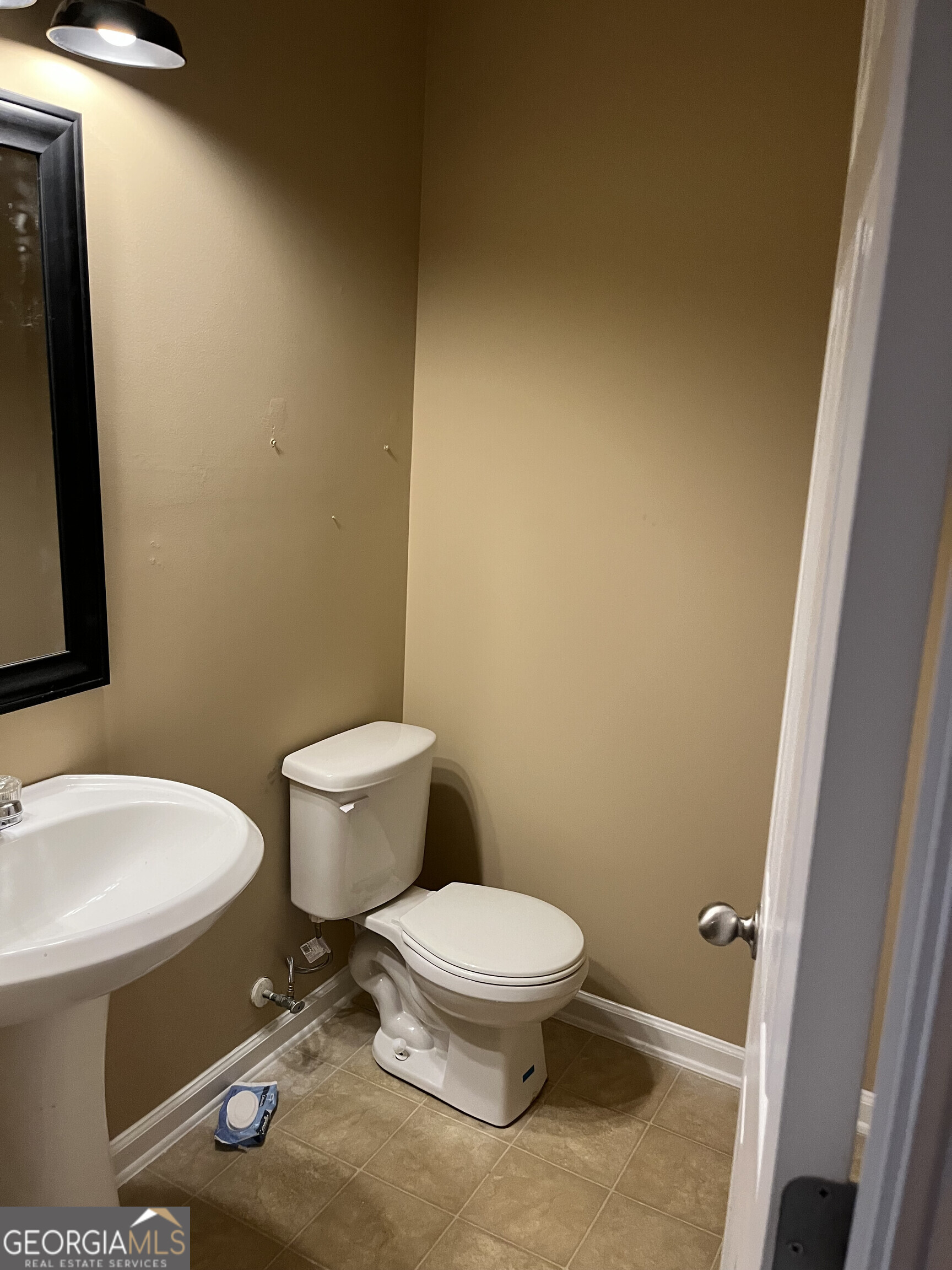 112 Granite Way Newnan, GA 30265 - Photo 7 of 22 a white toilet sitting next to a bathroom sink and a mirror