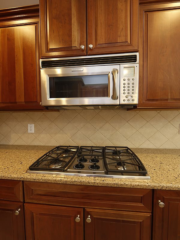 3324 Queensland Road Raleigh, NC 27614 - Photo 6 of 25 A close up of the cooktop and microwave. You can also see the tile backsplash. Appliances