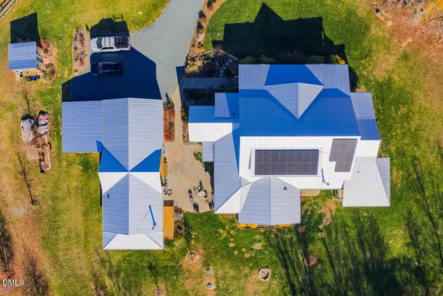 an aerial view of a house with swimming pool and big yard