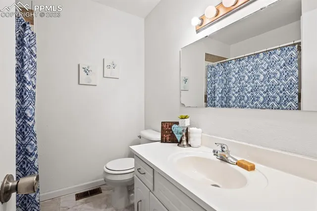 a bathroom with a sink a toilet and mirror