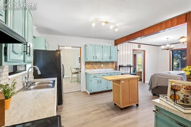 a kitchen with a sink refrigerator and cabinets