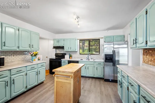 a kitchen with a sink stove cabinets and refrigerator