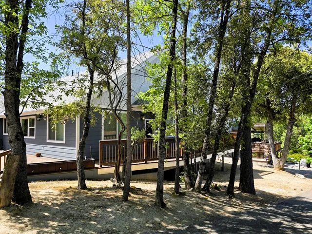 a front view of a house with a wooden deck and a yard