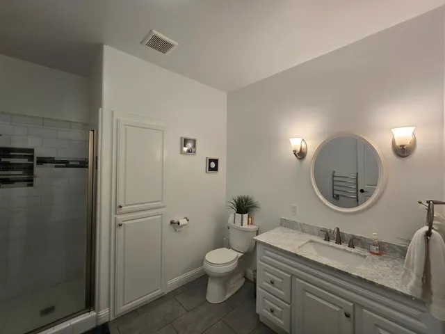a bathroom with a granite countertop double vanity sink and a mirror