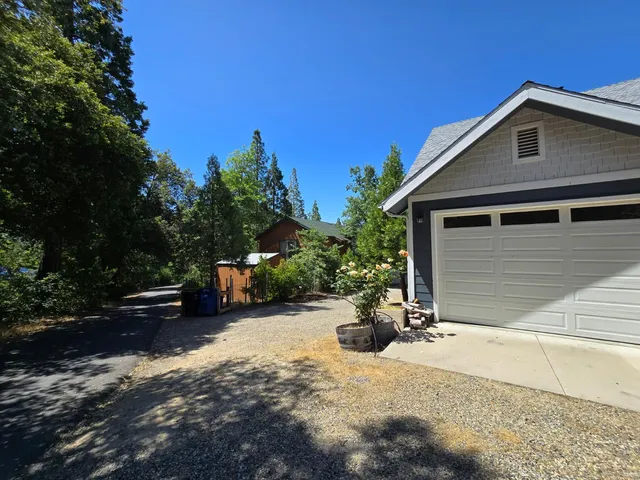 a view of a lush green forest with a house