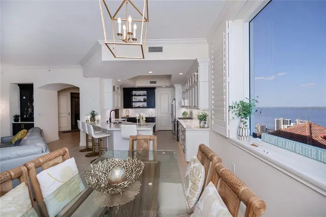 a living room with furniture kitchen view and a window