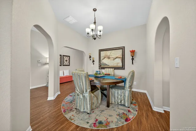 a dining room with furniture a chandelier and wooden floor