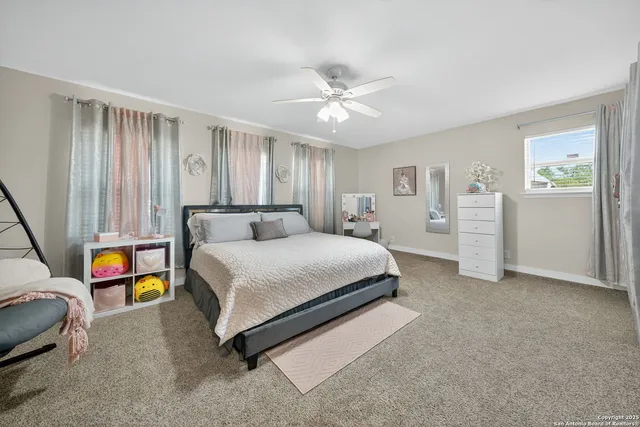 a spacious bedroom with a bed and a chandelier