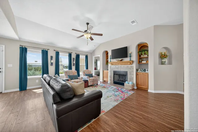 a living room with furniture a fireplace and a flat screen tv