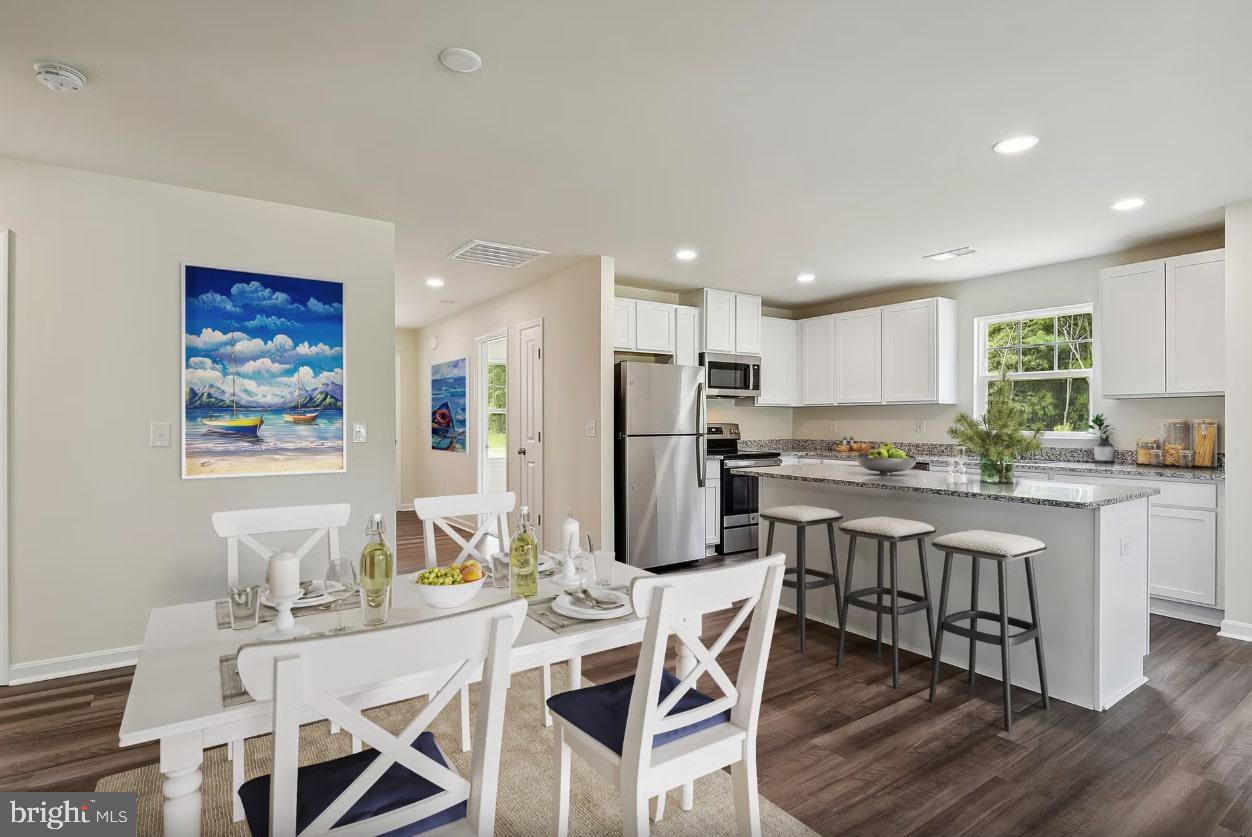 4 River Road Seaford, DE 19973 - Photo 4 of 6 a kitchen with stainless steel appliances kitchen island granite countertop a dining table chairs and a refrigerator