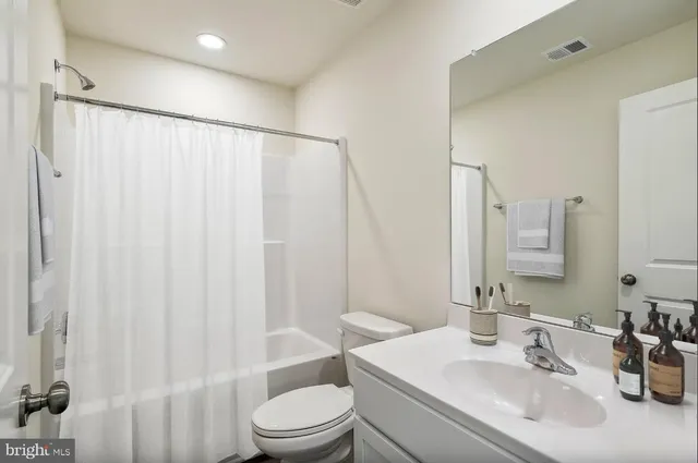 a bathroom with a sink a toilet and shower curtain