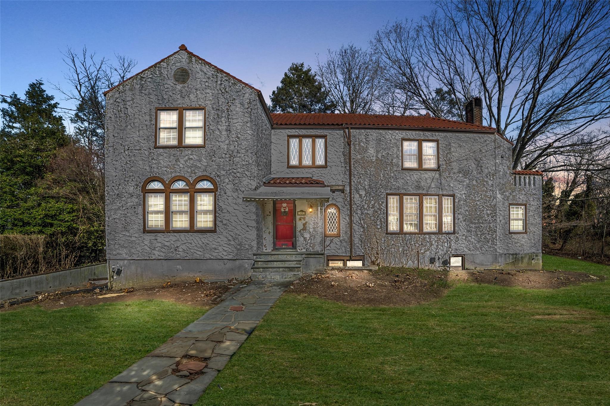 47 Brookfield Road Mount Vernon, NY 10552 - Photo 1 of 1 View of front facade with a front lawn, a chimney, stucco siding, and a tile roof