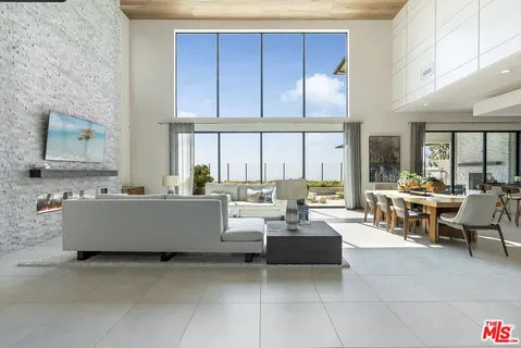 a spacious bedroom with a bed and large glass window