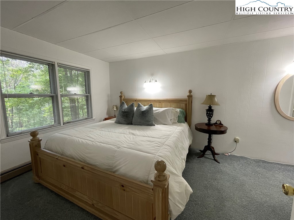 911 Pine Ridge Road Beech Mountain, NC 28604 - Photo 11 of 22 a bed sitting in a bedroom next to a window