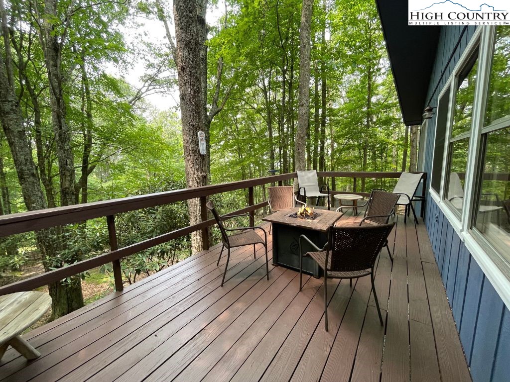 911 Pine Ridge Road Beech Mountain, NC 28604 - Photo 2 of 22 a view of a deck with table and chairs and wooden floor