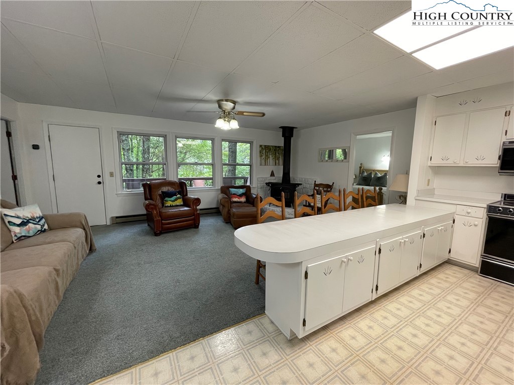 911 Pine Ridge Road Beech Mountain, NC 28604 - Photo 6 of 22 a living room with furniture a window and a chandelier