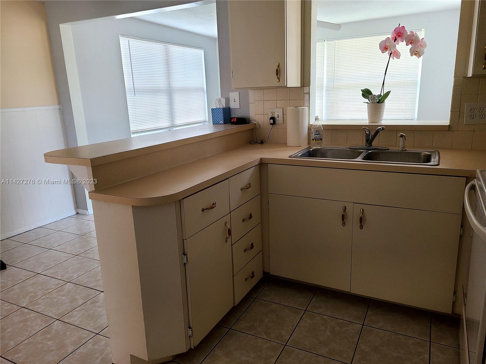 11204 Harding Drive Port Richey, FL 34668 - Photo 4 of 6 a kitchen with a sink cabinets and a window
