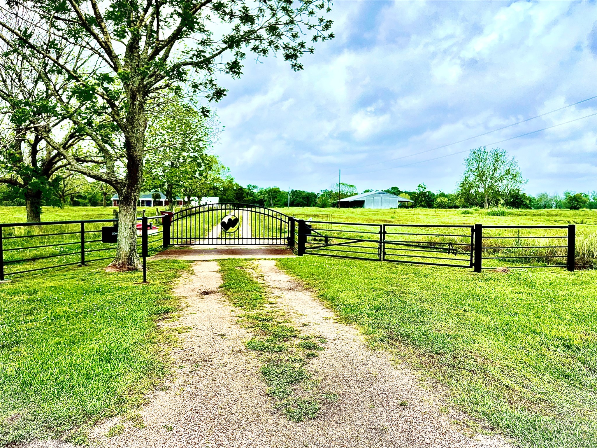 37243 FM 521 Road Bay City, TX 77414 - Photo 4 of 50 Steel entry gate with automatic opener. New 21” diameter drainage culverts installed in 2019 sized for drainage in extreme rain events. Railroad bed gravel was used to build the all-weather road-way and it is compacted and established.
