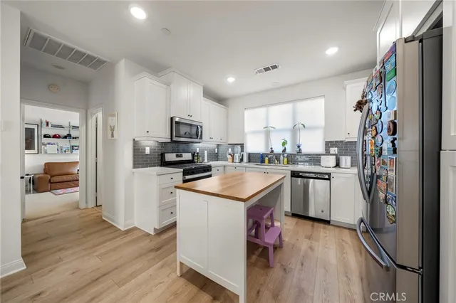 a kitchen with granite countertop a refrigerator stove top oven and sink