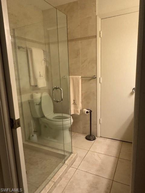 1261 Pine Ridge Road Naples, FL 34108 - Photo 12 of 13 Bathroom featuring tile patterned floors, a stall shower, and tile walls