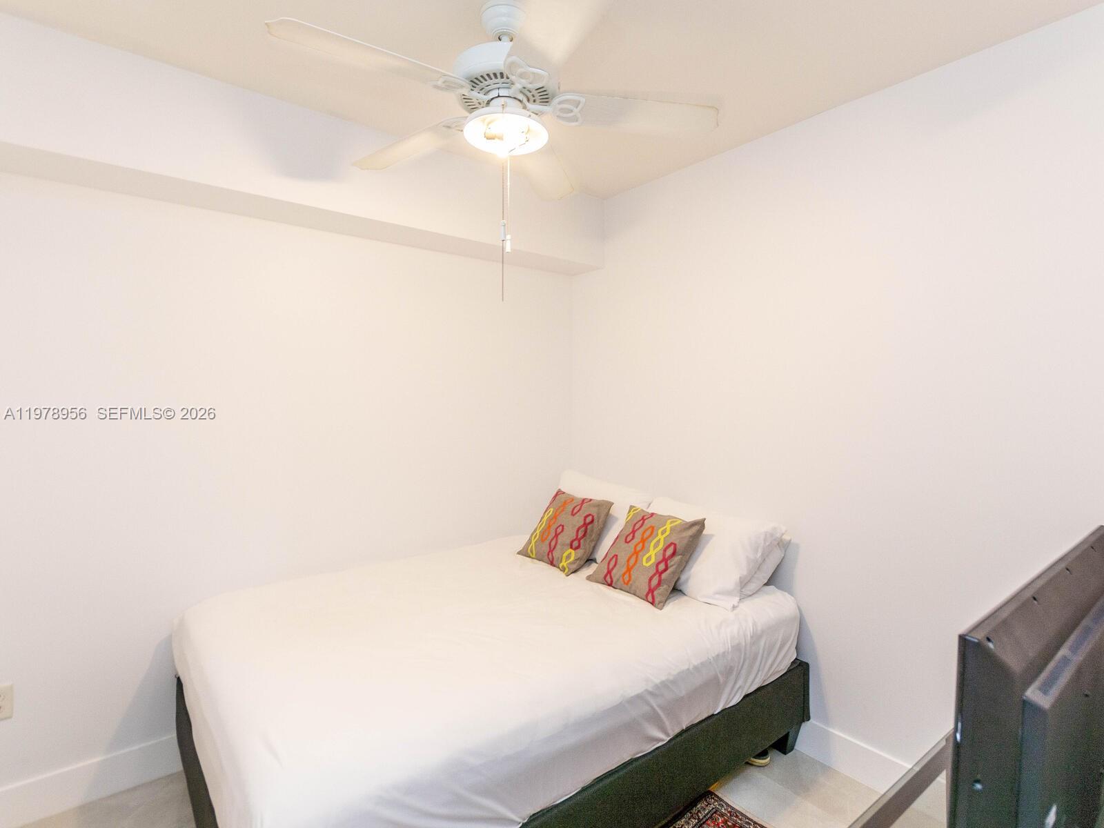 7350 Southwest 89th Street, Unit 719S Miami, FL 33156 - Photo 20 of 30 a bedroom with a bed and a ceiling fan