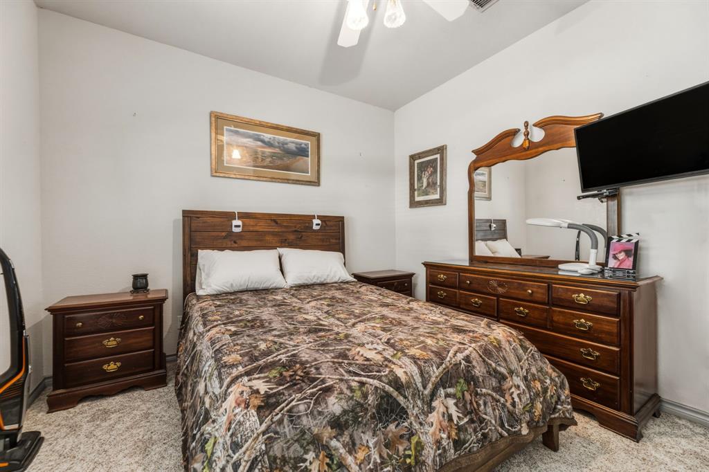 130 Blazek Road Alma, TX 75119 - Photo 28 of 34 a bedroom with a bed and a flat screen tv