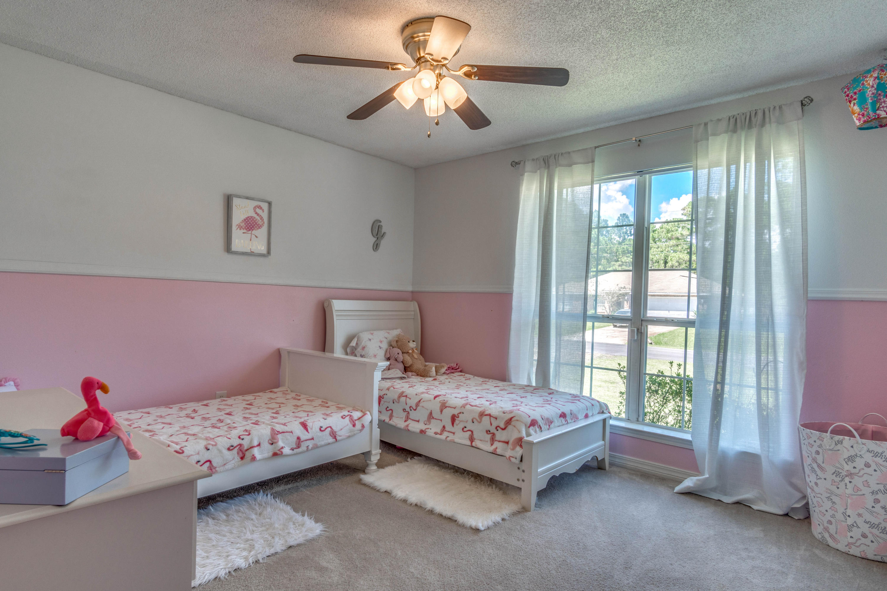 7105 Snug Waters Road Navarre, FL 32566 - Photo 19 of 42 a bedroom with a bed and a chandelier fan
