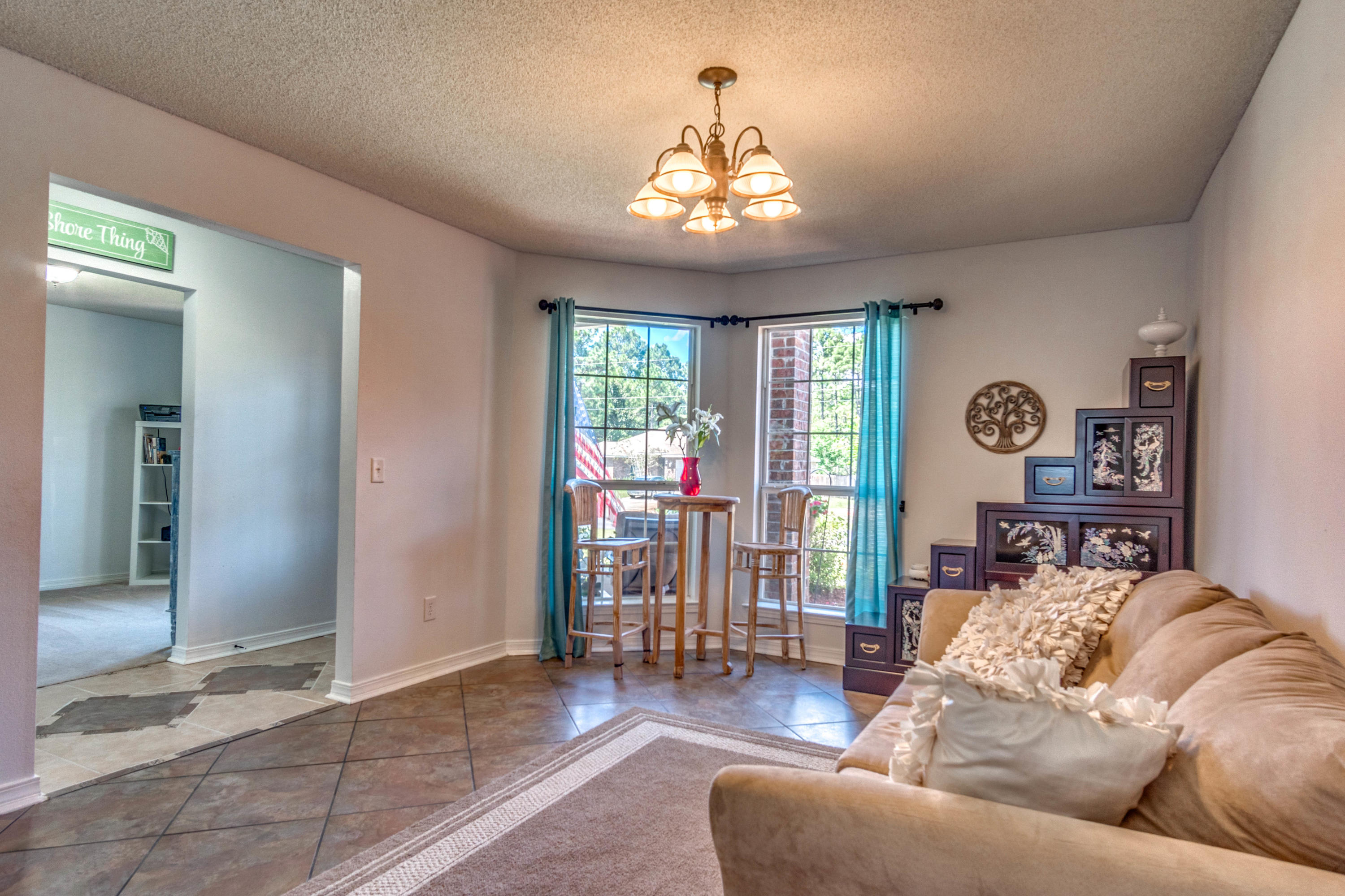 7105 Snug Waters Road Navarre, FL 32566 - Photo 26 of 42 a living room with furniture and a chandelier