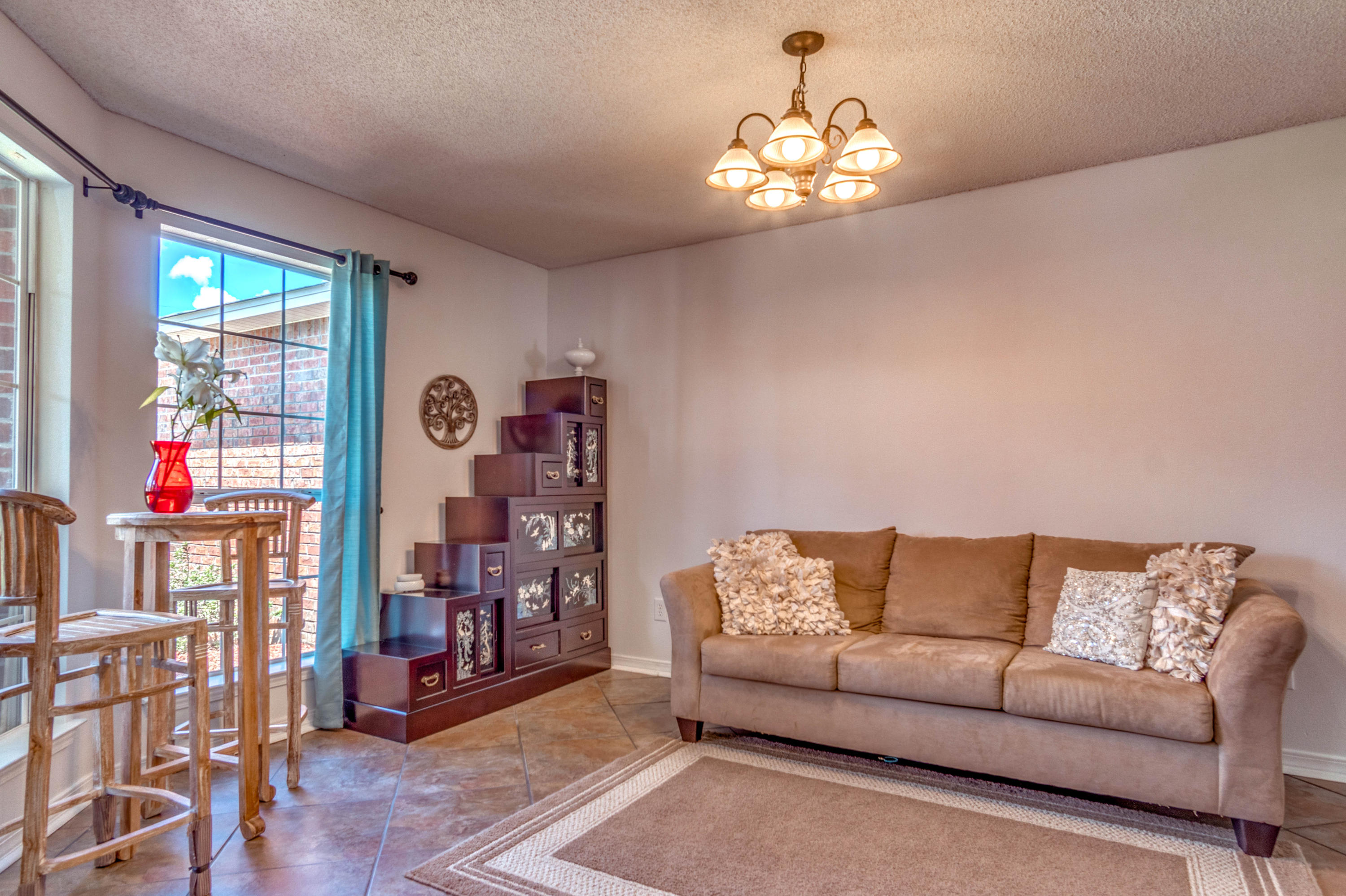 7105 Snug Waters Road Navarre, FL 32566 - Photo 27 of 42 a living room with furniture and a chandelier