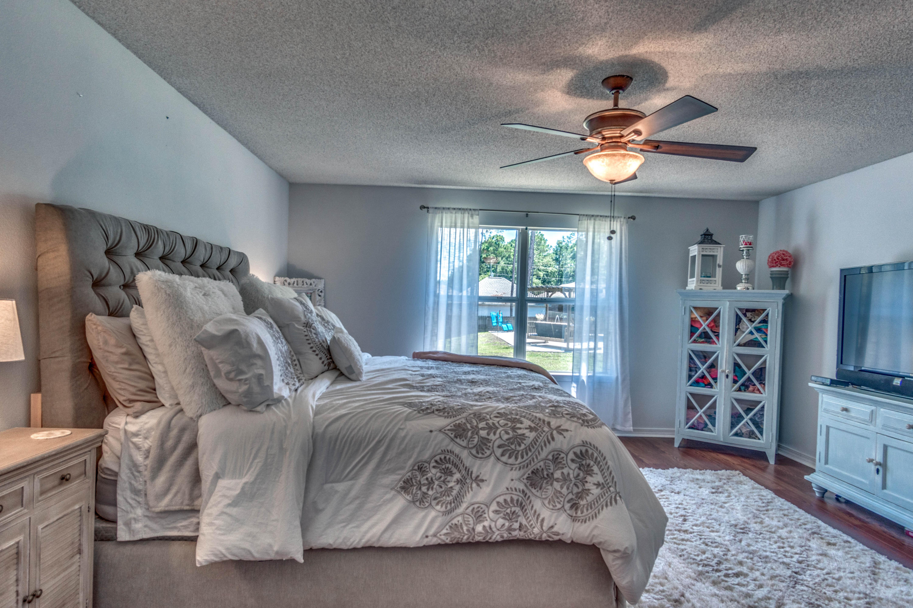 7105 Snug Waters Road Navarre, FL 32566 - Photo 31 of 42 a bedroom with a bed and a flat tv screen on dresser