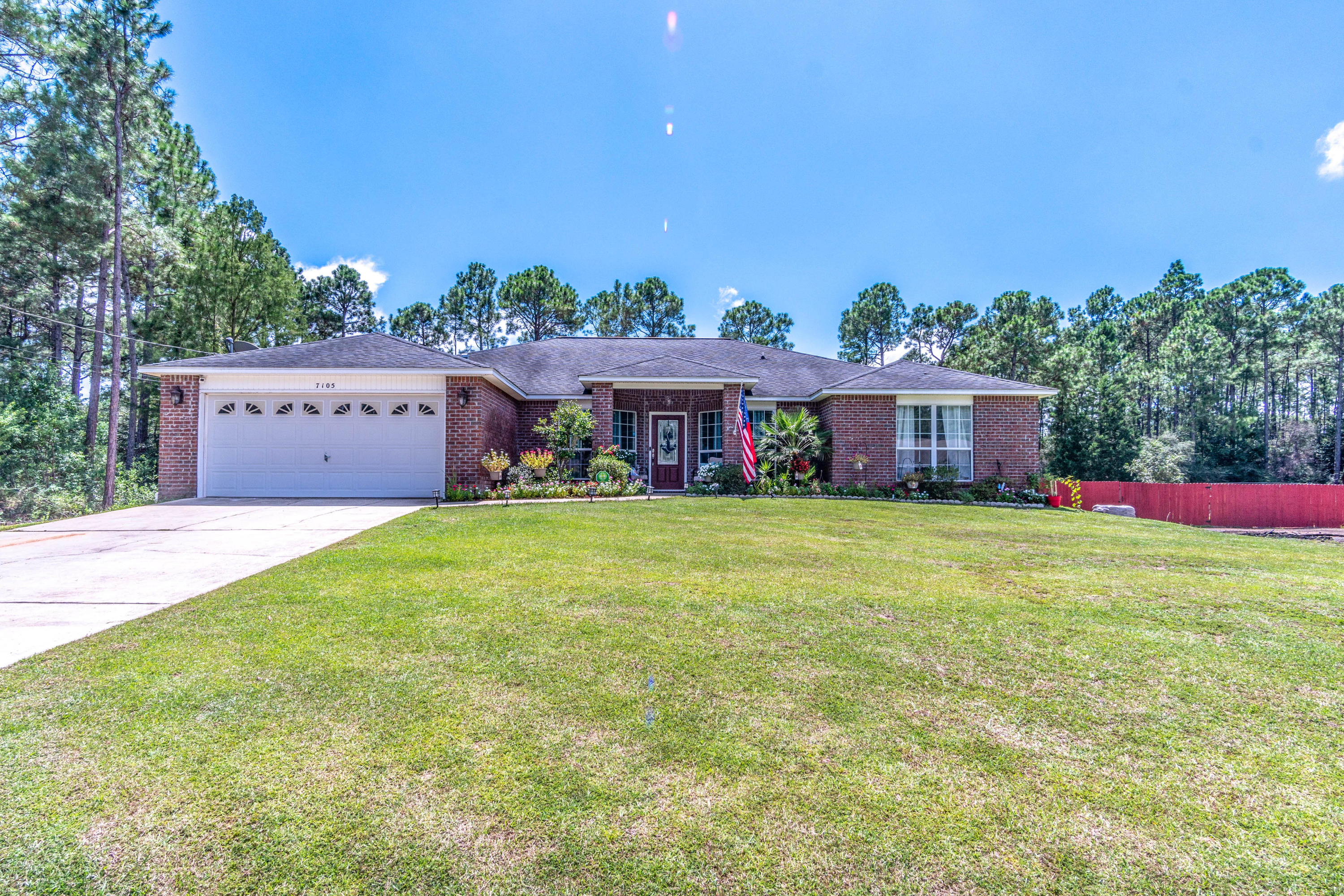 7105 Snug Waters Road Navarre, FL 32566 - Photo 38 of 42 a front view of a house with a garden and deck