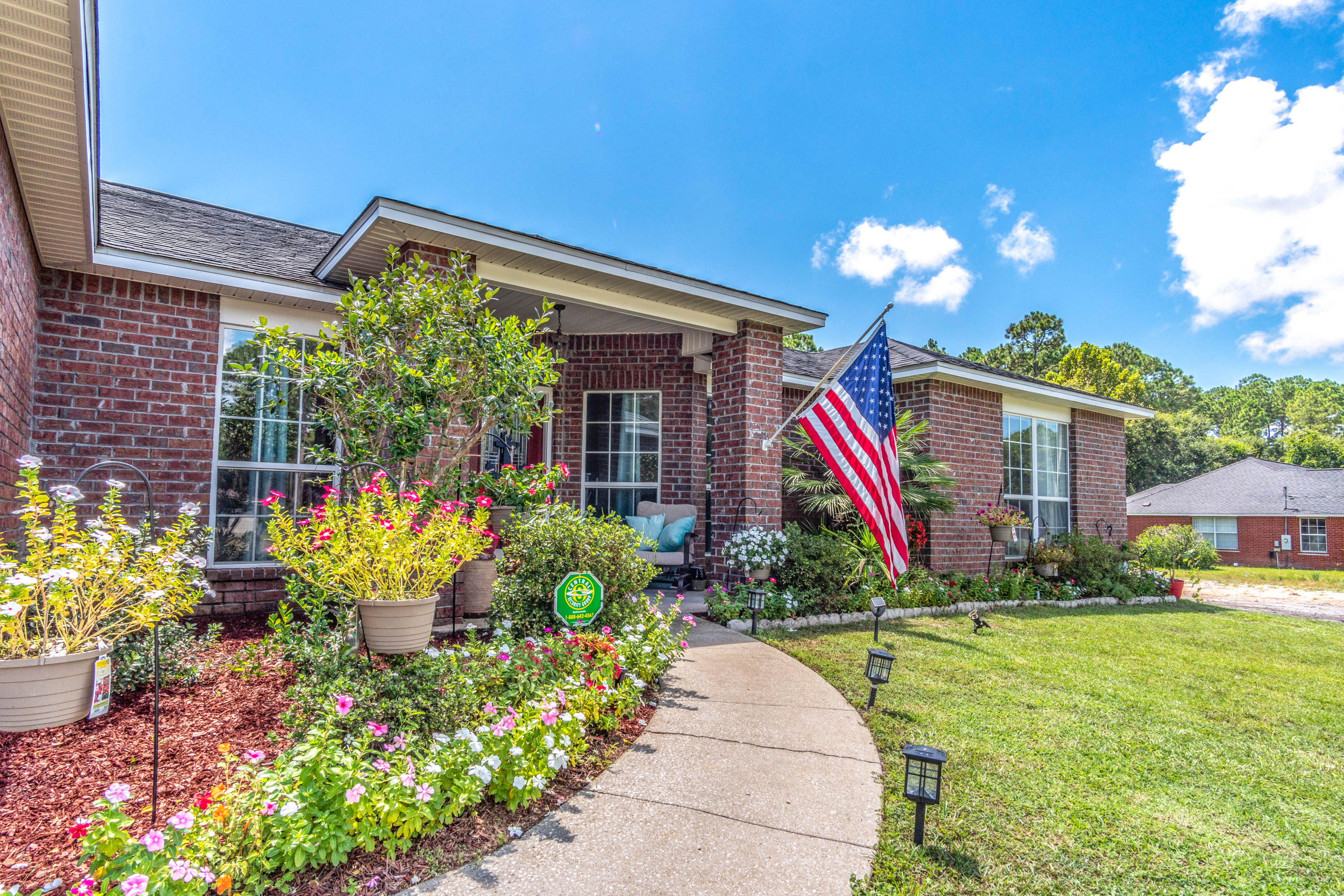 7105 Snug Waters Road Navarre, FL 32566 - Photo 40 of 42 a front view of a house with a yard and potted plants