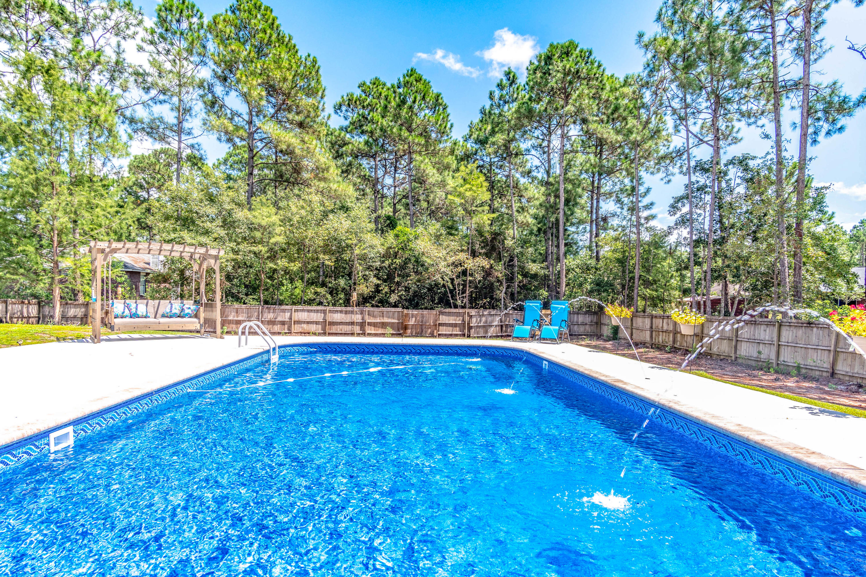 7105 Snug Waters Road Navarre, FL 32566 - Photo 4 of 42 a view of swimming pool with an outdoor space and seating area
