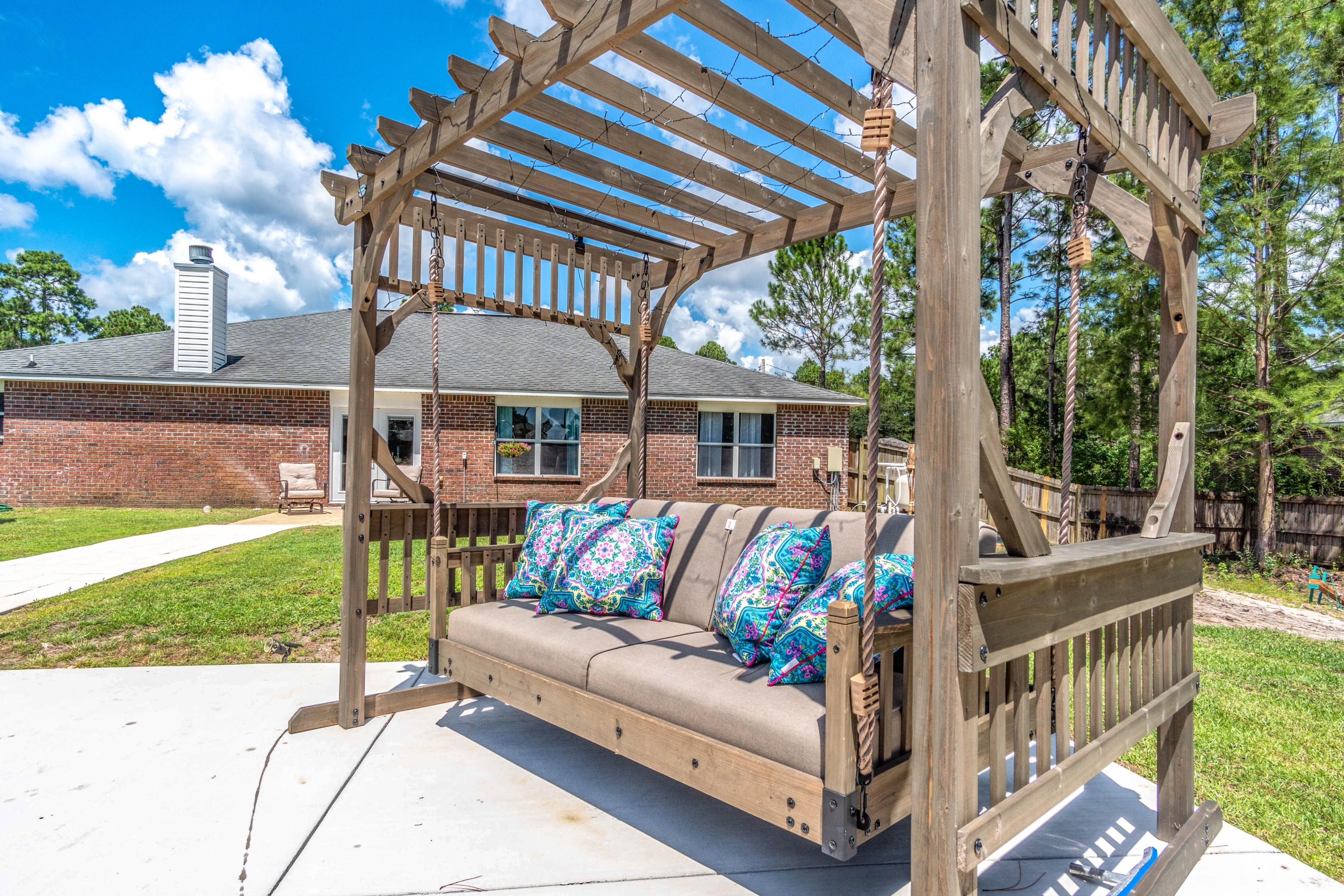 7105 Snug Waters Road Navarre, FL 32566 - Photo 41 of 42 a view of a patio with couches table and chairs and garden