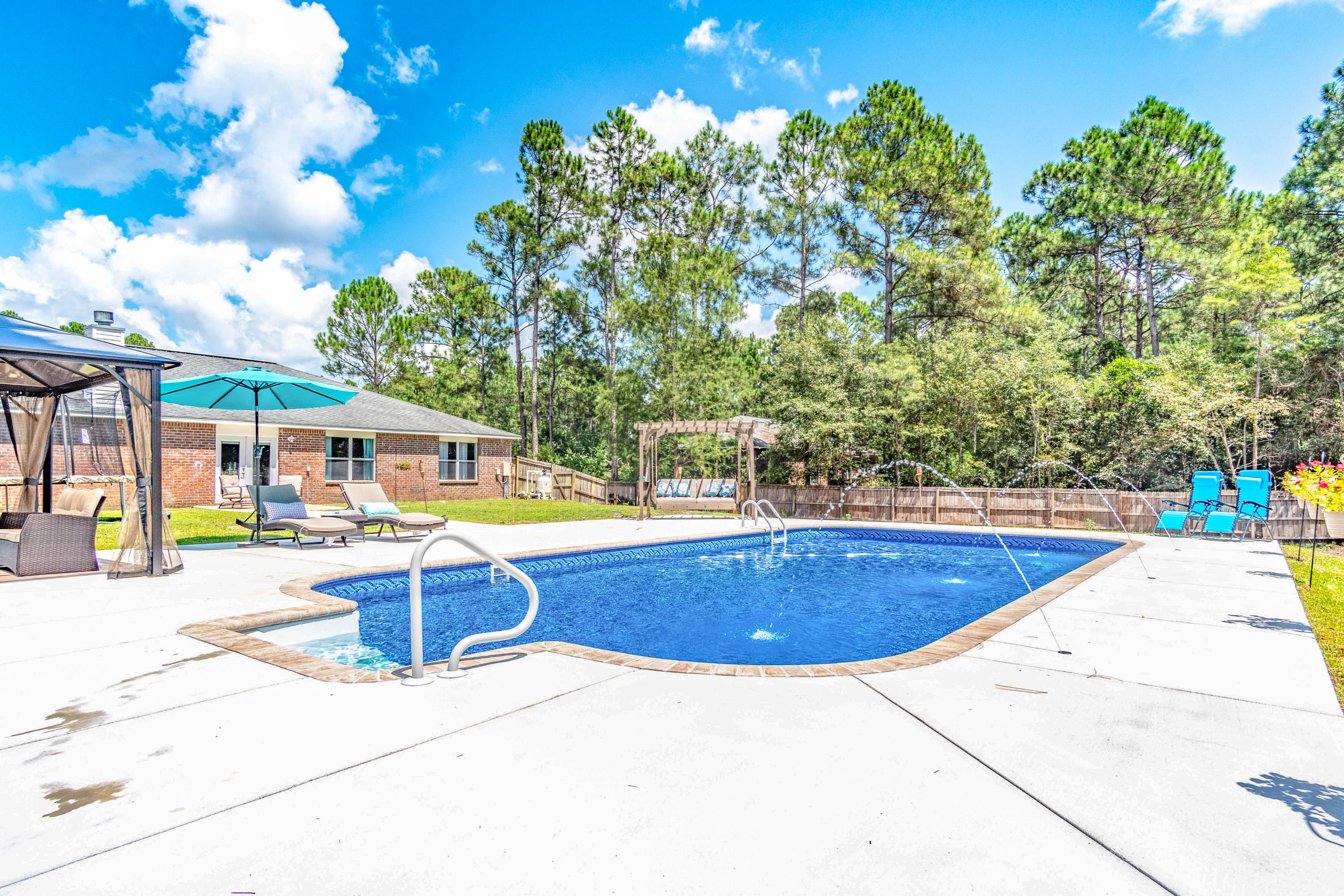 7105 Snug Waters Road Navarre, FL 32566 - Photo 5 of 42 a view of a swimming pool with a lounge chairs