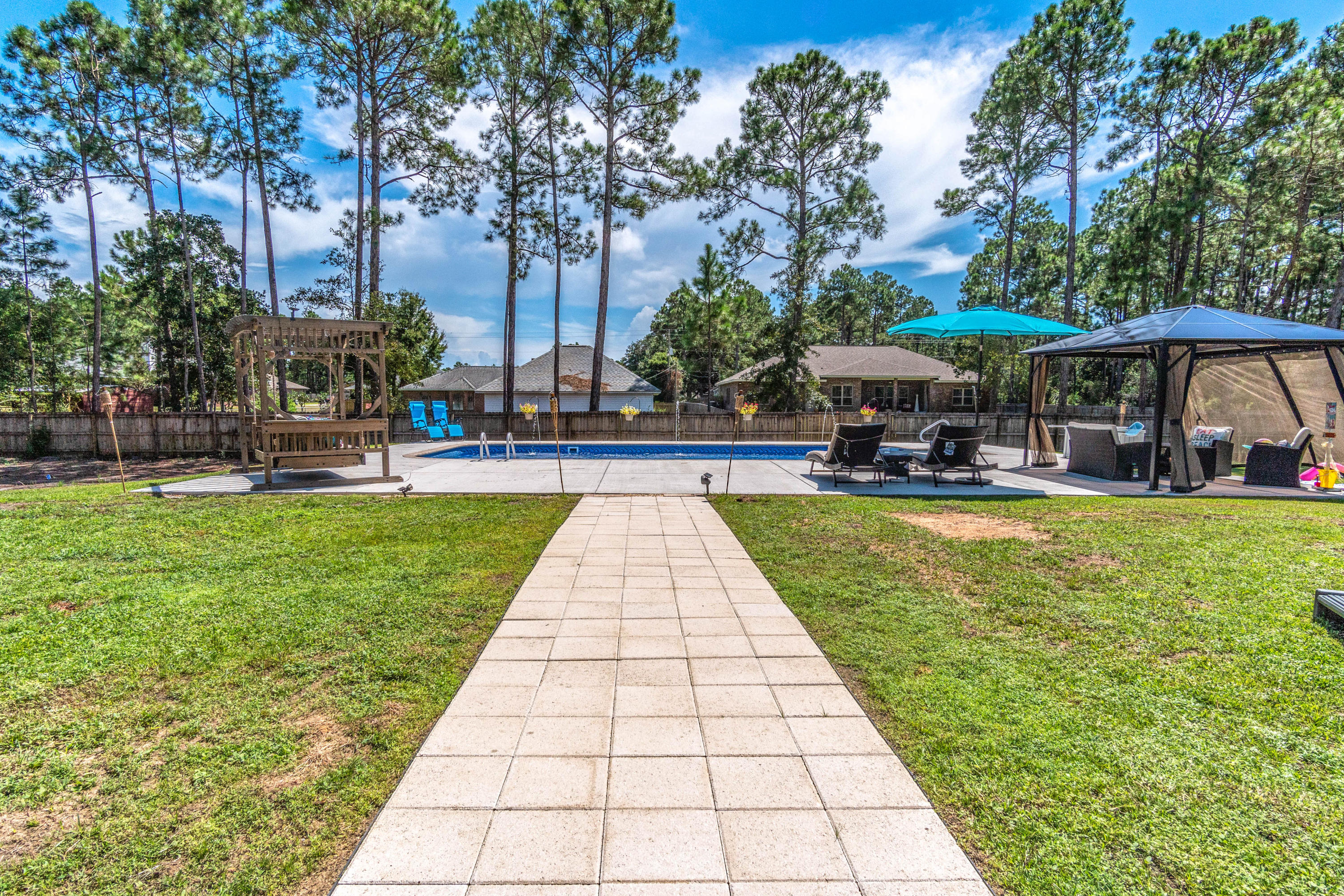 7105 Snug Waters Road Navarre, FL 32566 - Photo 6 of 42 a swimming pool with outdoor seating and yard